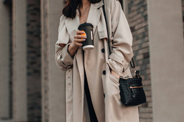 woman walking and drinking coffee against the background of the city