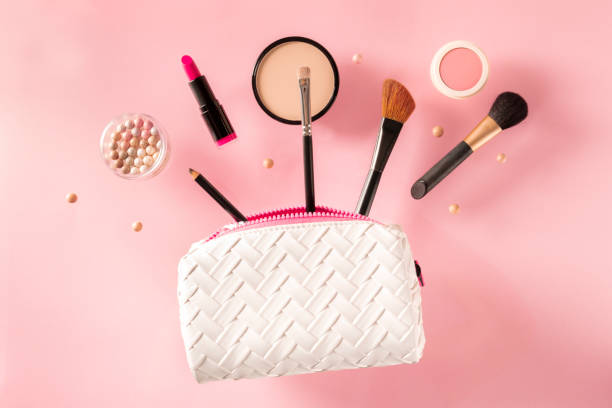 Professional makeup, flying out of a bag, on a pink background.