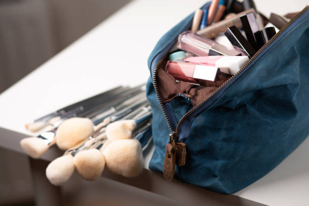 Textile bag with decorative cosmetics and brushes on a table. Closeup shot